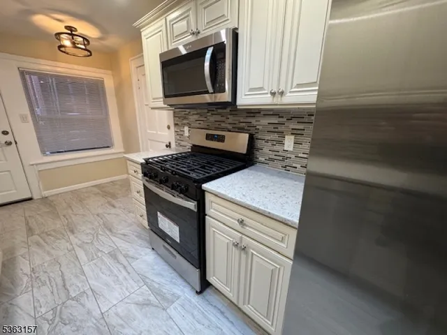 a kitchen with granite countertop a stove and a microwave