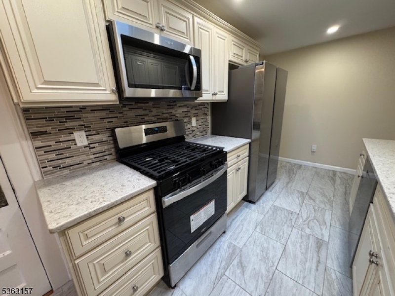 527 West 8th Street, Unit B Plainfield, NJ 07060 - Photo 15 of 30 a kitchen with stainless steel appliances granite countertop a stove microwave and refrigerator