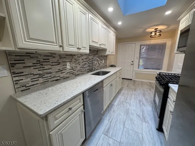 a kitchen with granite countertop a sink stove and cabinets