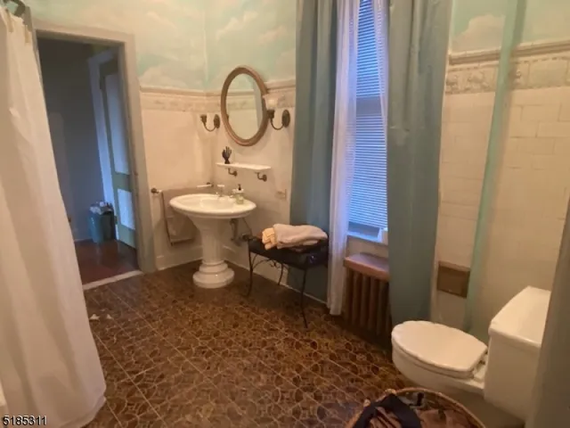 a bathroom with a toilet a sink and a mirror