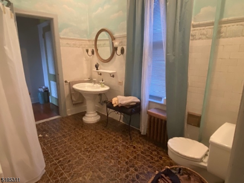 527 West 8th Street, Unit B Plainfield, NJ 07060 - Photo 18 of 30 a bathroom with a toilet a sink and a mirror