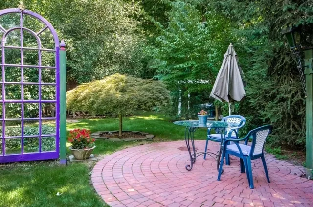 a view of a patio with a table and chairs under an umbrella