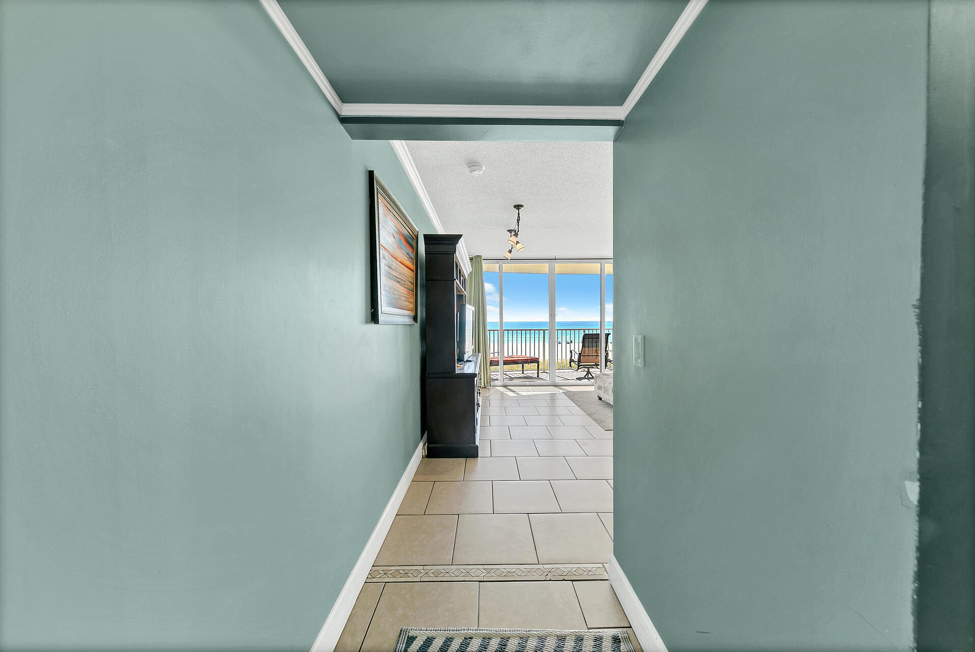 10515 Front Beach Road, Unit 102 Panama City Beach, FL 32407 - Photo 2 of 19 a hallway with a dining table and a mirror