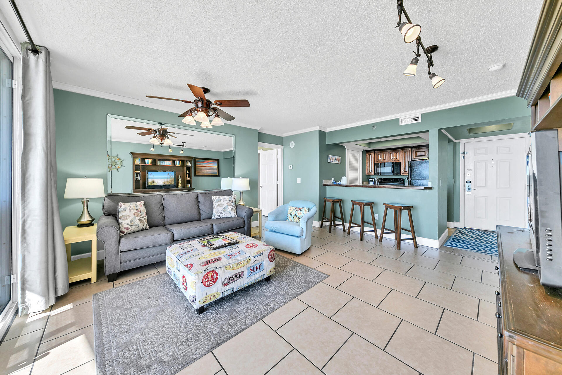10515 Front Beach Road, Unit 102 Panama City Beach, FL 32407 - Photo 7 of 19 a living room with furniture and a chandelier