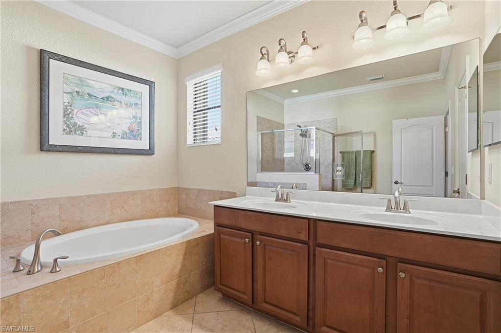 3915 Treasure Cove Circle Naples, FL 34114 - Photo 12 of 24 Full bath featuring double vanity, a stall shower, a garden tub, crown molding, and light tile patterned floors