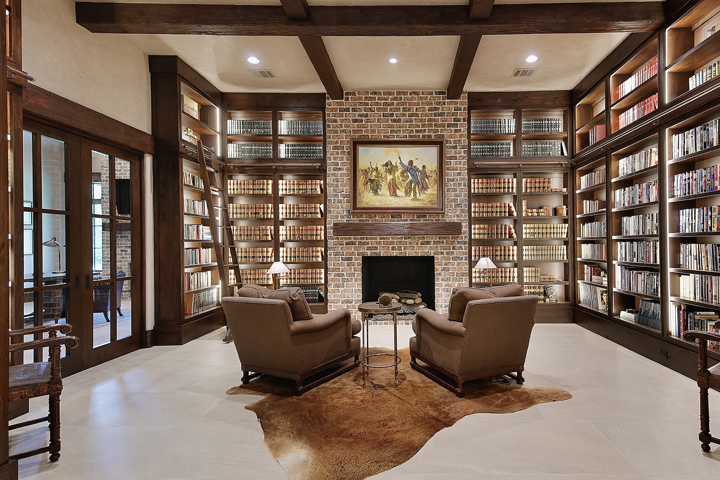 40693 Center Hill Road Hempstead, TX 77445 - Photo 7 of 50 Floor to ceiling shelving, a library ladder, brick gas log fireplace, exposed beams and stone tile flooring.