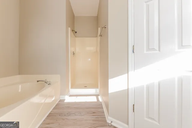 a bathroom with a tub shower and sink