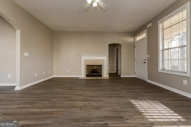 a view of empty room with wooden floor and fireplace
