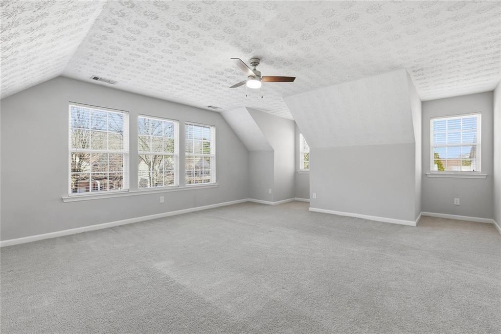 3570 Bogan Mill Road Northeast Buford, GA 30519 - Photo 25 of 31 an empty room with windows and ceiling fan