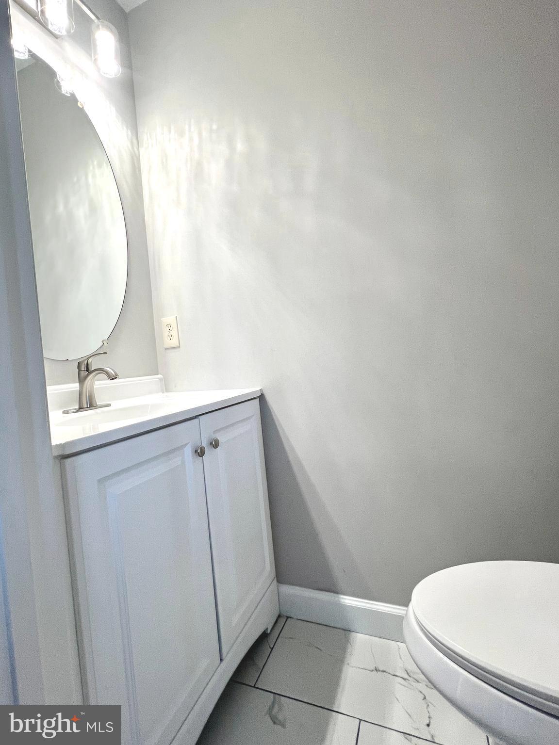 2026 Weitzel Court Frederick, MD 21702 - Photo 12 of 30 a bathroom with a sink mirror vanity and toilet