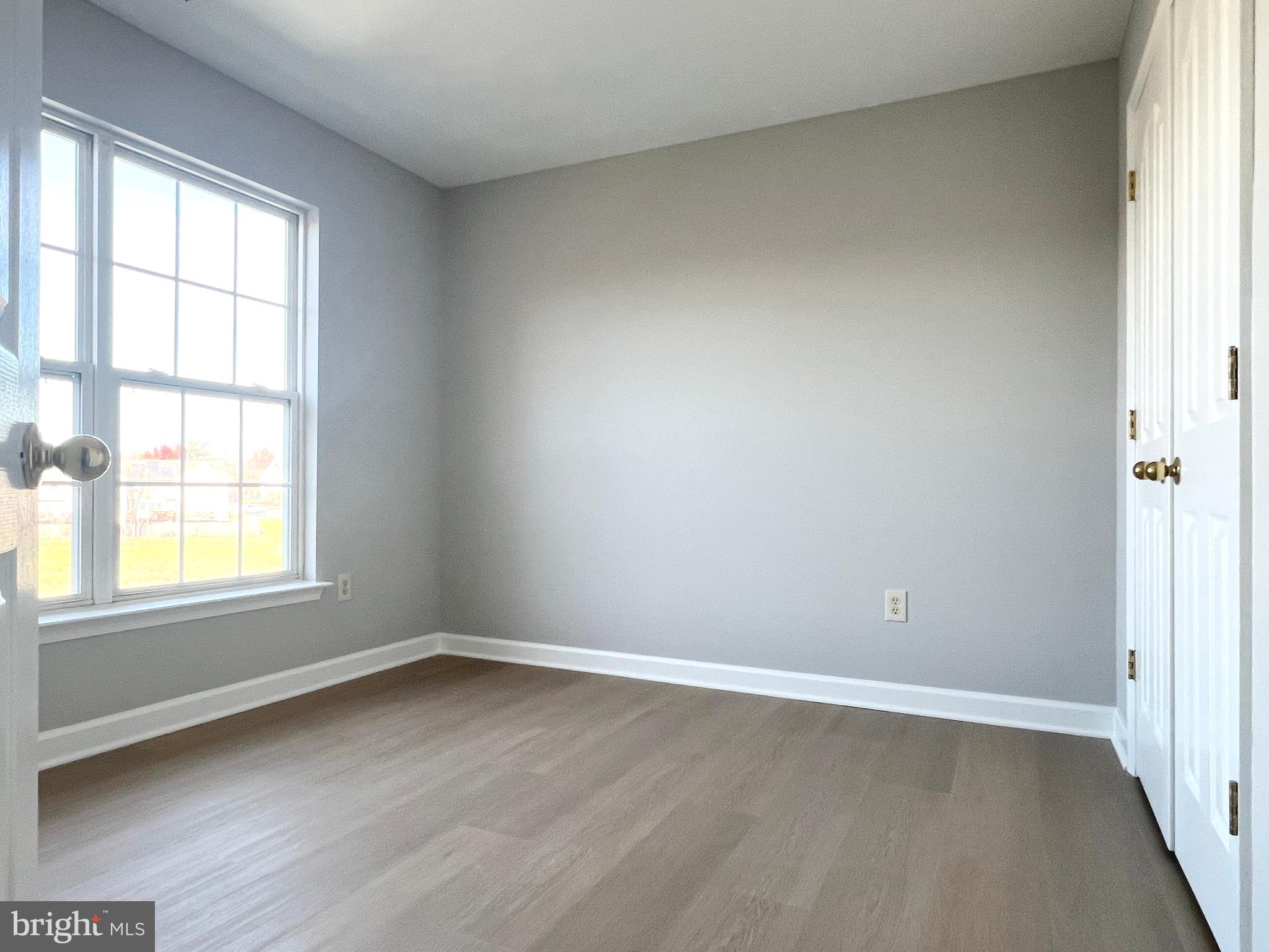 2026 Weitzel Court Frederick, MD 21702 - Photo 25 of 30 an empty room with wooden floor and windows