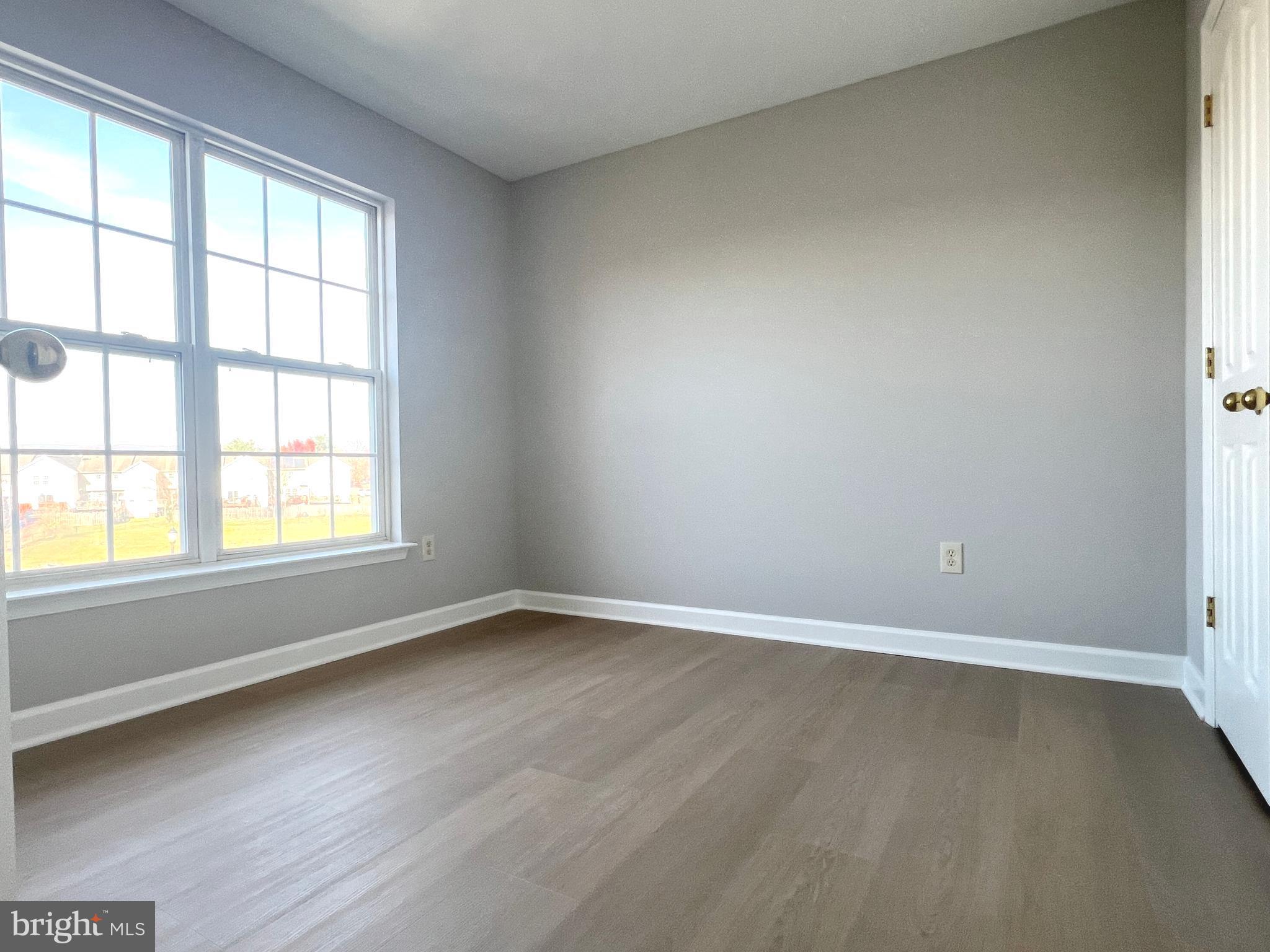 2026 Weitzel Court Frederick, MD 21702 - Photo 26 of 30 an empty room with wooden floor and windows