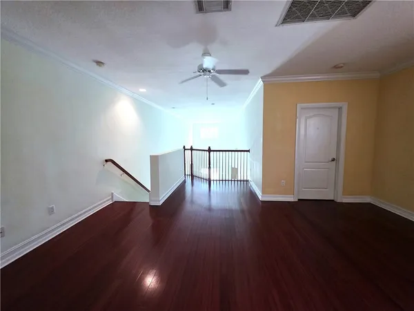 a view of a livingroom with wooden floor and a ceiling fan