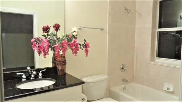 a bathroom with a granite countertop sink a mirror and shower