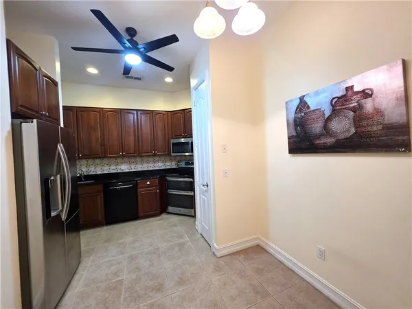 a kitchen with a refrigerator and a stove top oven