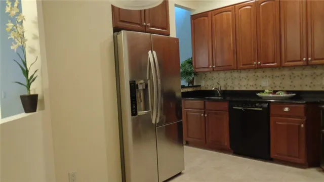 a kitchen with stainless steel appliances granite countertop a refrigerator and a sink