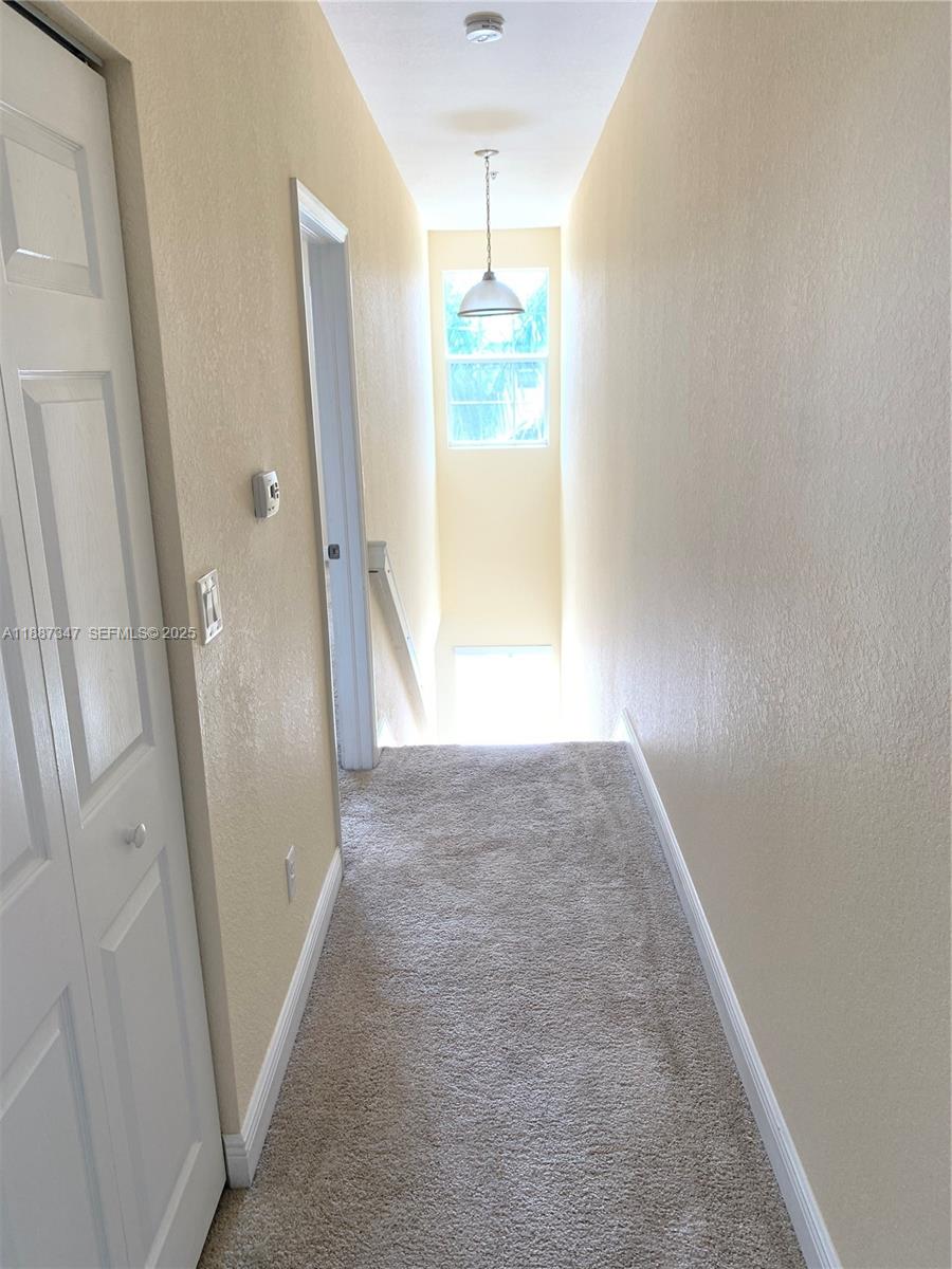 1044 Southwest 147th Avenue, Unit 10105 Pembroke Pines, FL 33027 - Photo 16 of 23 a view of hallway with window and wooden floor