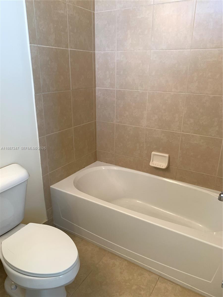 1044 Southwest 147th Avenue, Unit 10105 Pembroke Pines, FL 33027 - Photo 21 of 23 a white toilet sitting next to a bath tub