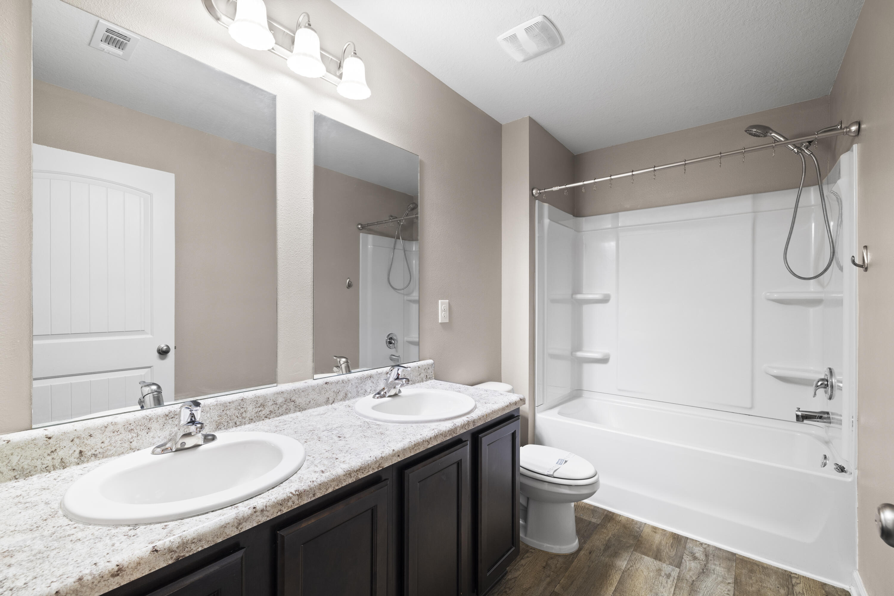 814 Moorhen Way Crestview, FL 32539 - Photo 5 of 29 a bathroom with a granite countertop sink toilet a large mirror a bathtub and shower