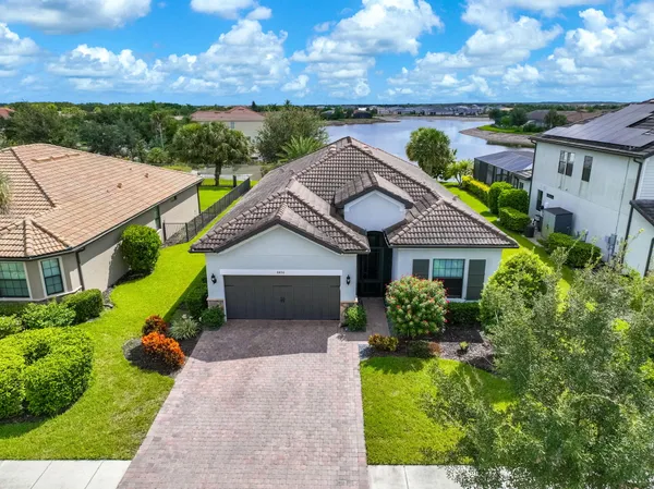 a aerial view of a house with a yard and a large tree