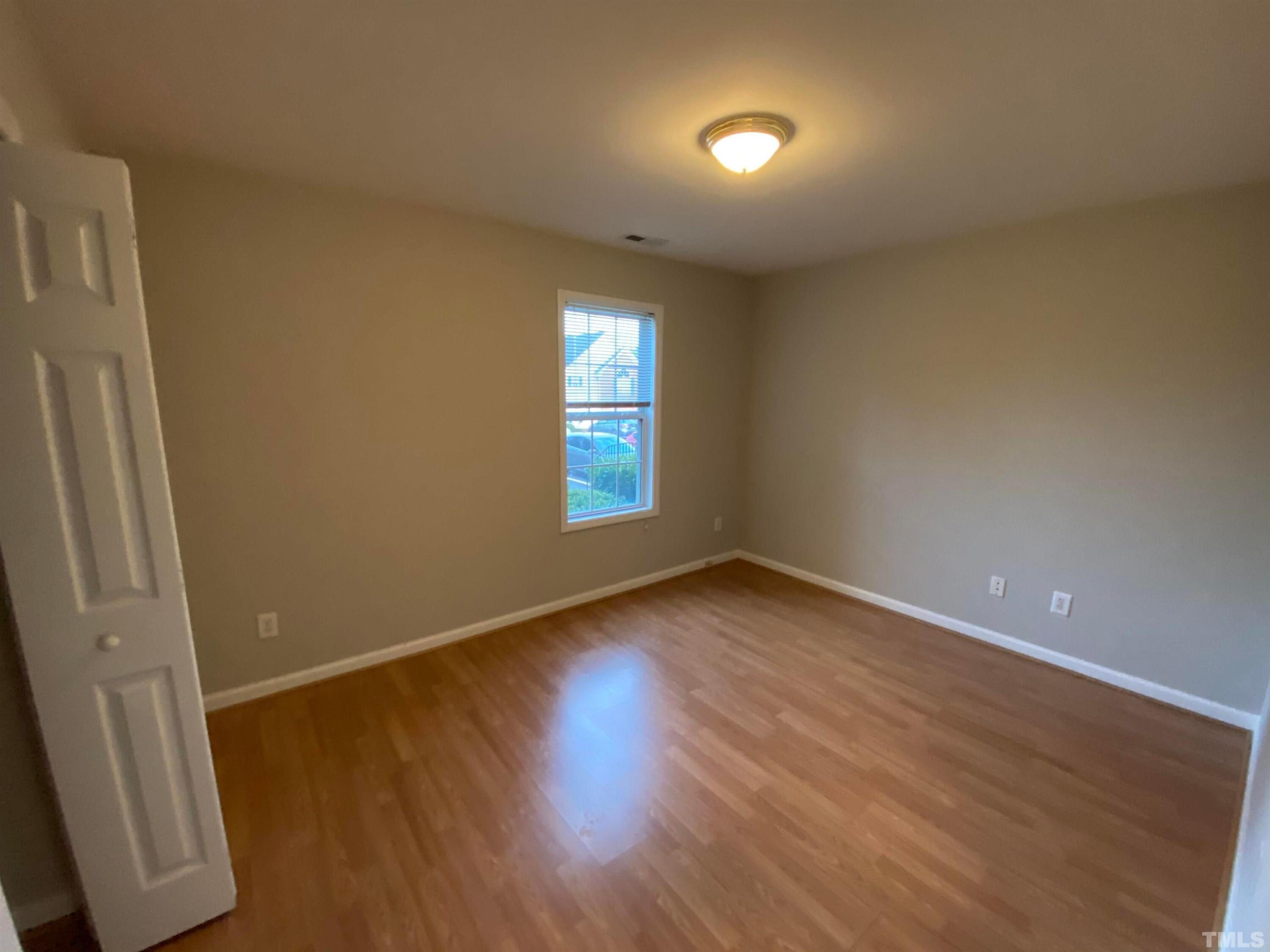 2413 Wellington Ridge Loop, Unit 2413 Cary, NC 27518 - Photo 17 of 30 an empty room with wooden floor and windows