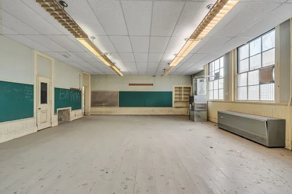 a view of an empty room with a fireplace and window