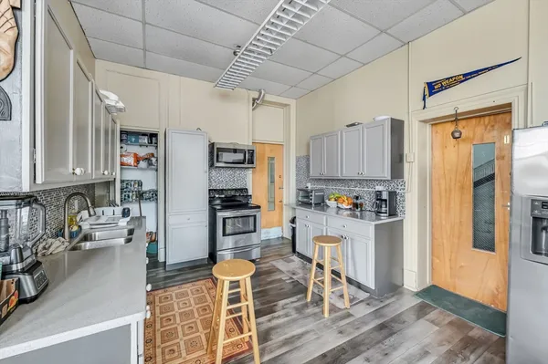 a kitchen with stainless steel appliances kitchen island granite countertop a refrigerator and microwave