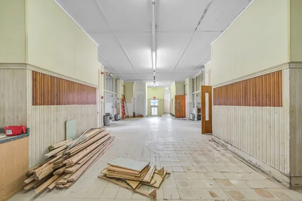 a view of a hallway with a window and chandelier