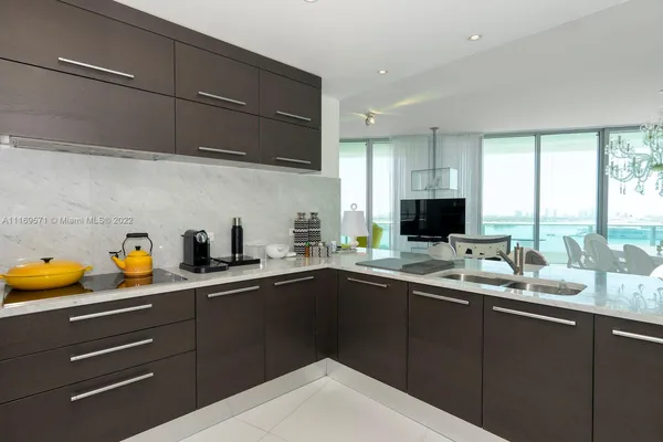 a metallic refrigerator freezer and a stove sitting inside of a kitchen