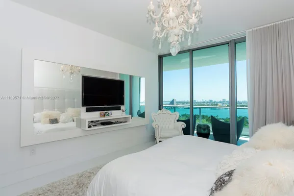 a bedroom with a bed and a chandelier