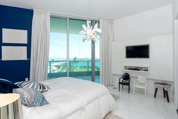a bedroom with a bed and a flat screen tv