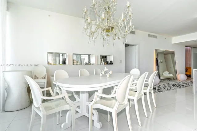 a kitchen with stainless steel appliances a table chairs sink and cabinets