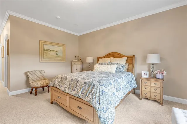 a bedroom with a bed and a lamp on dresser