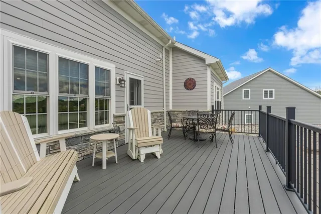 a view of a house with wooden deck and outdoor seating