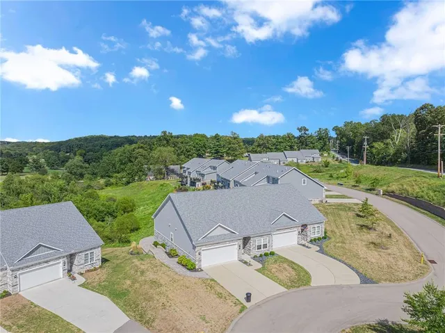 an aerial view of a house with garden space and street view