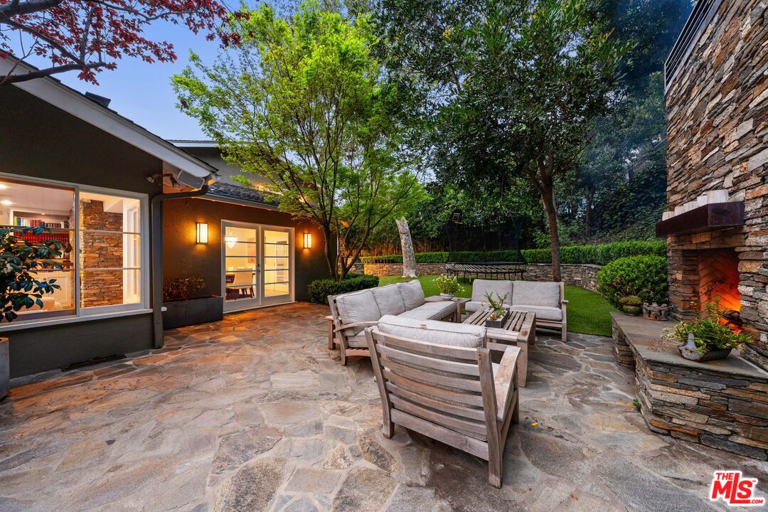 3354 Mandeville Canyon Road Los Angeles, CA 90049 - Photo 17 of 63 a view of a patio with chairs and potted plants