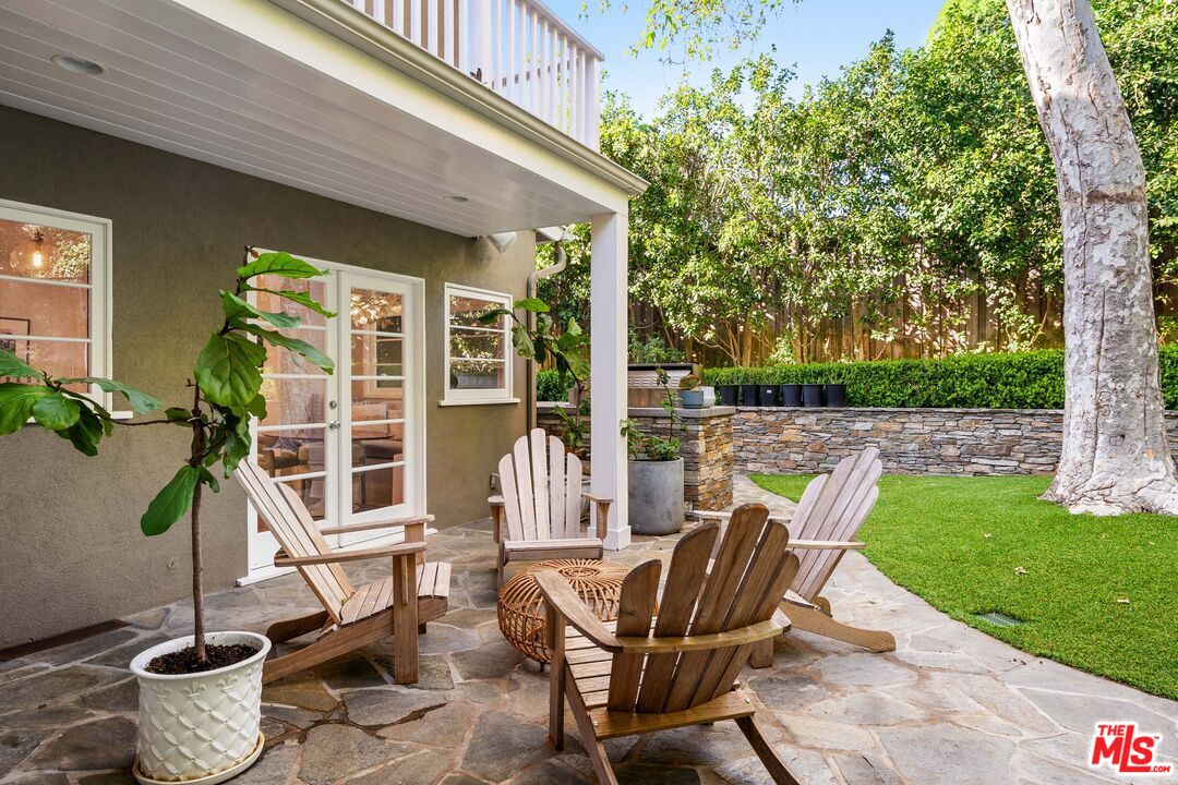 3354 Mandeville Canyon Road Los Angeles, CA 90049 - Photo 27 of 63 a view of a patio with table and chairs potted plants and floor to ceiling window