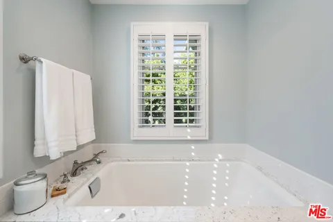 a bathroom with a sink mirror and a shower