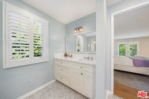 a bedroom with furniture and a large window