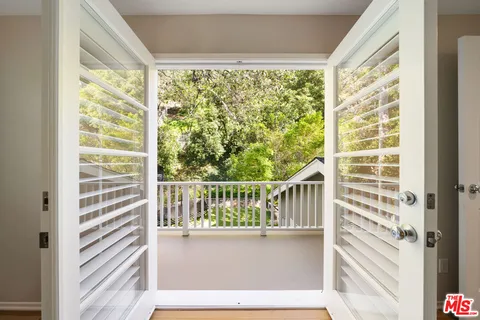 a bedroom with a bed and large windows