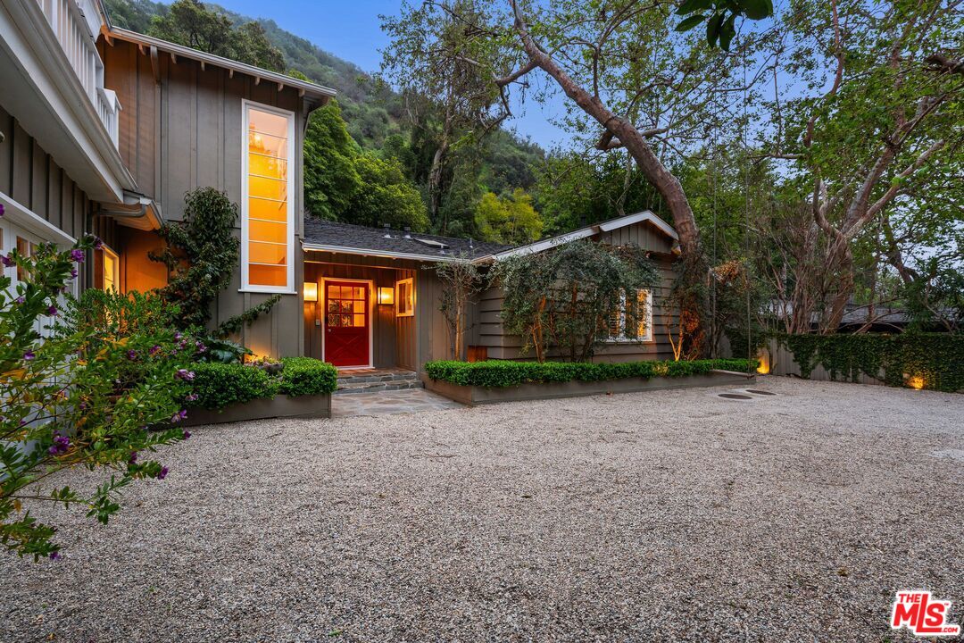 3354 Mandeville Canyon Road Los Angeles, CA 90049 - Photo 63 of 63 a front view of a house with a yard and garage