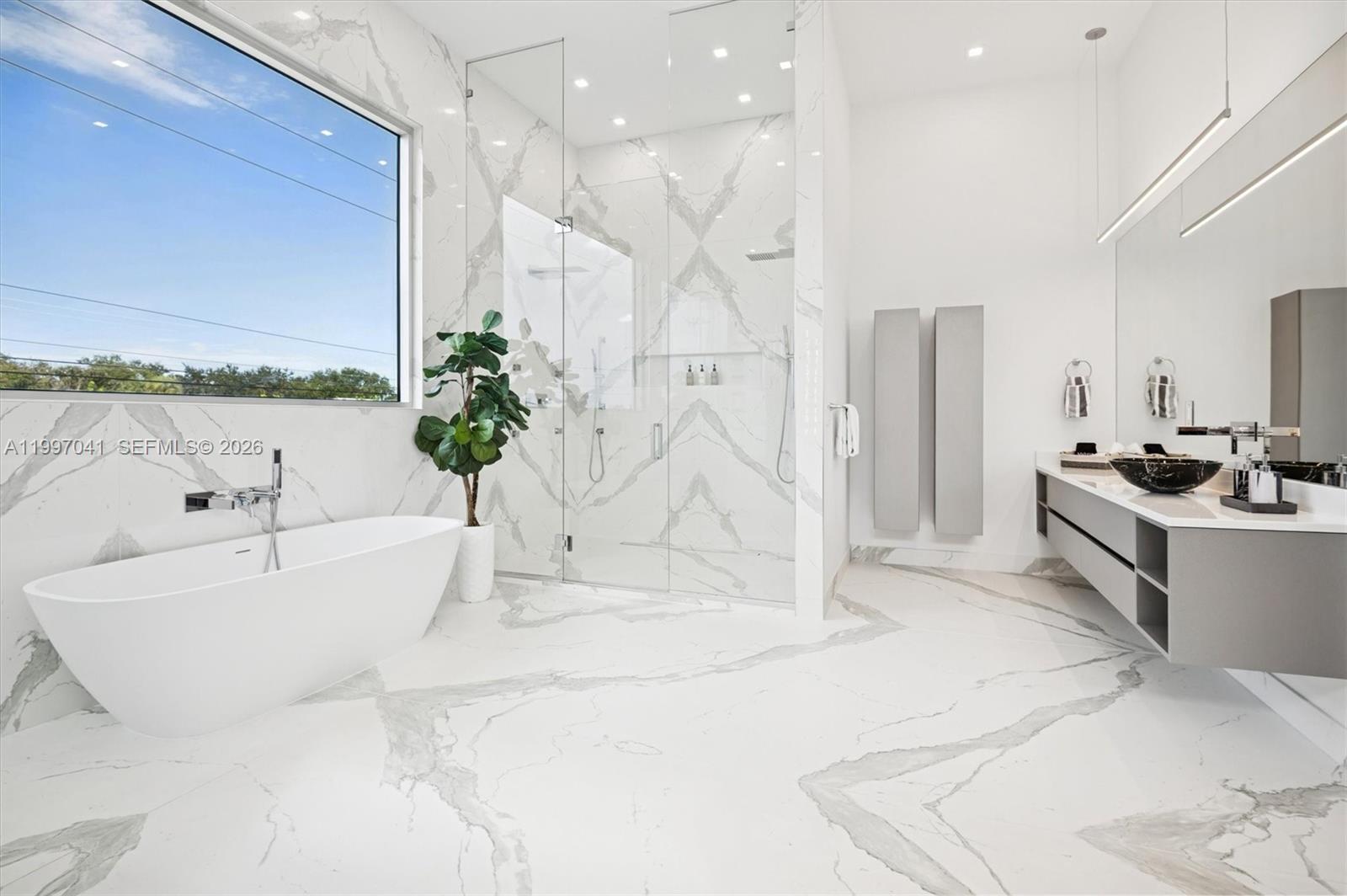 2628 Marcinski Road Jupiter, FL 33477 - Photo 28 of 50 a spacious bathroom with a bathtub and a chandelier