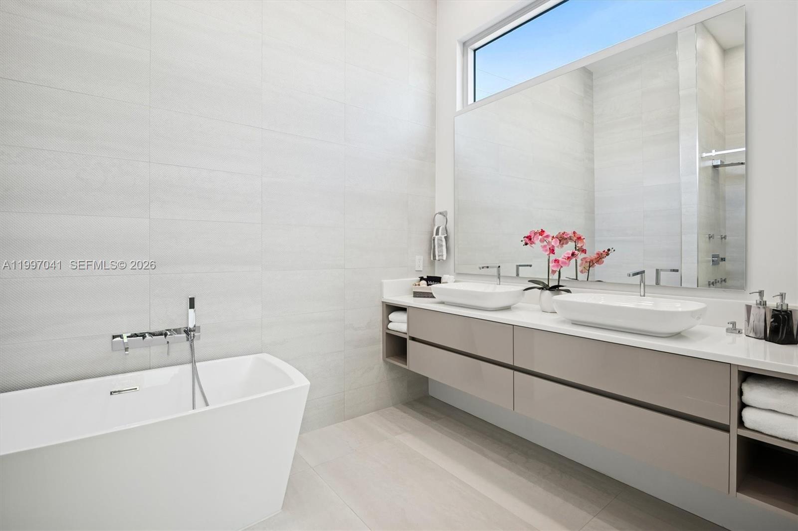 2628 Marcinski Road Jupiter, FL 33477 - Photo 34 of 50 a bathroom with a tub sink and mirror