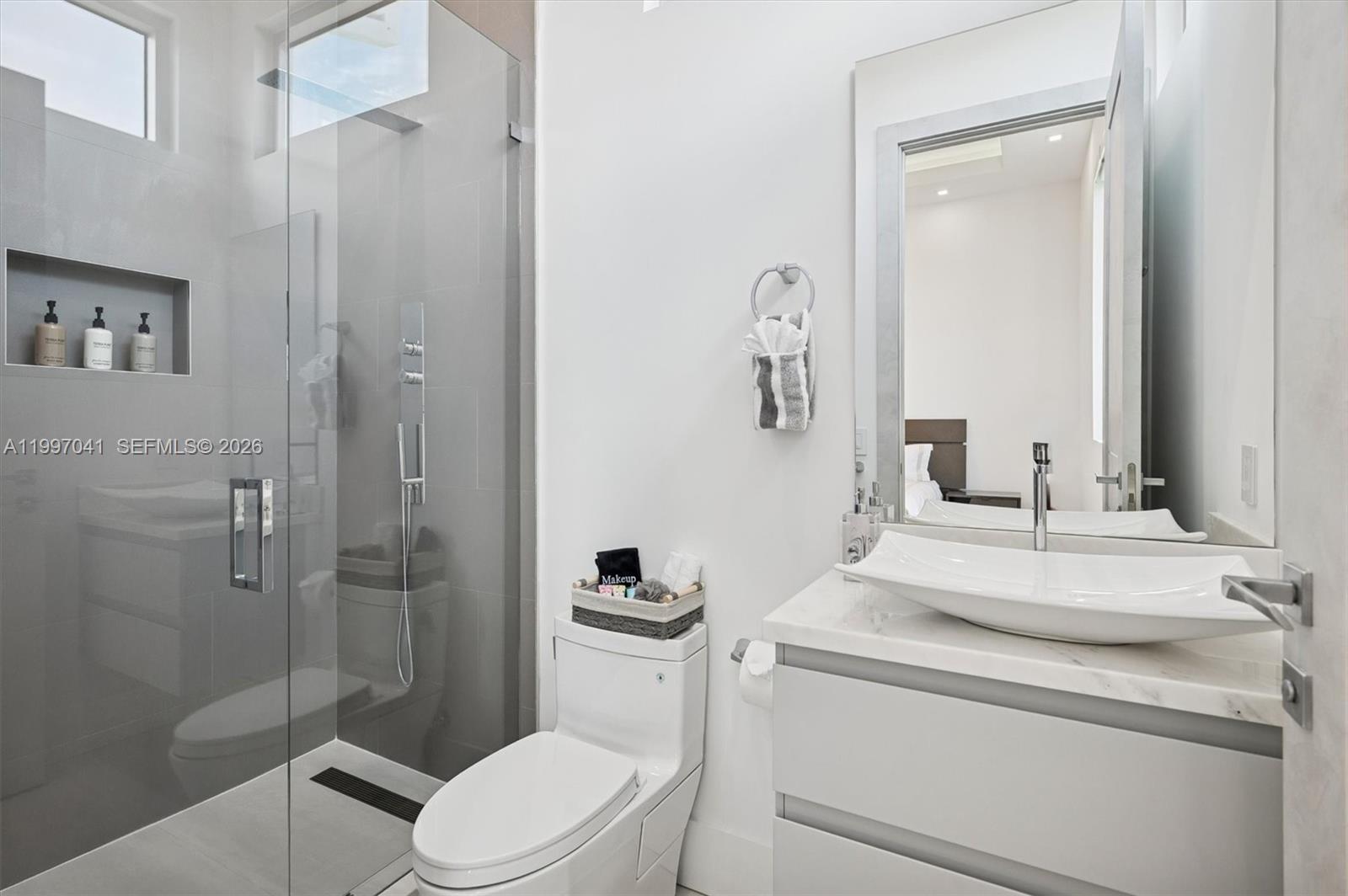 2628 Marcinski Road Jupiter, FL 33477 - Photo 39 of 50 a bathroom with a granite countertop sink toilet and shower