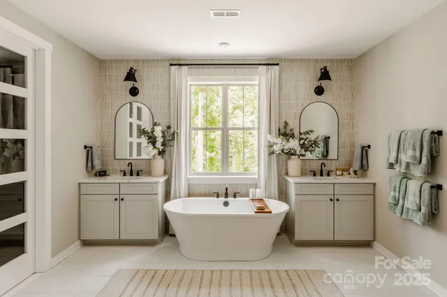 a large white kitchen with sink a window and stainless steel appliances