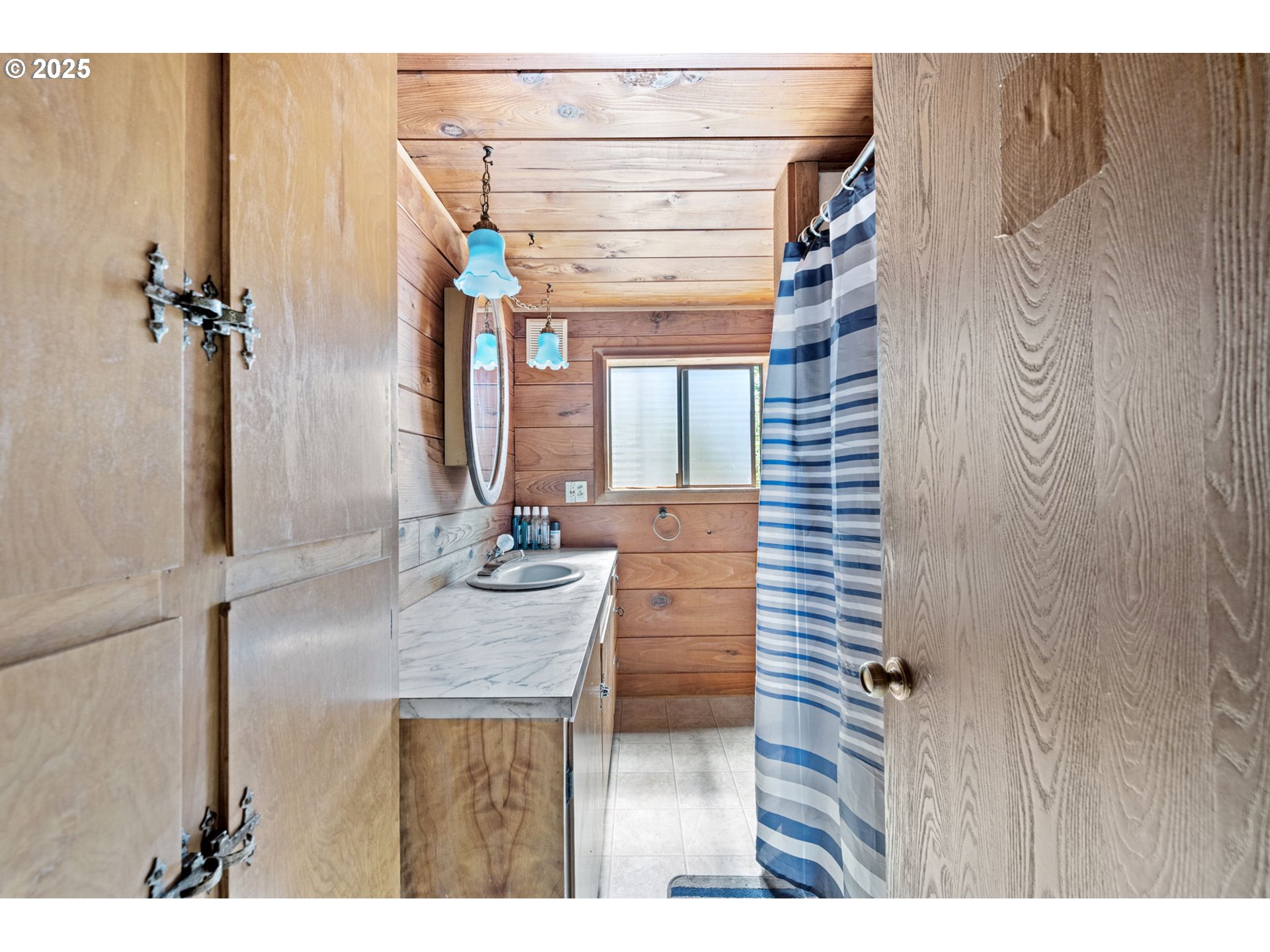 89731 Indian Creek Road Swisshome, OR 97480 - Photo 9 of 46 a bathroom with a sink a mirror and shower