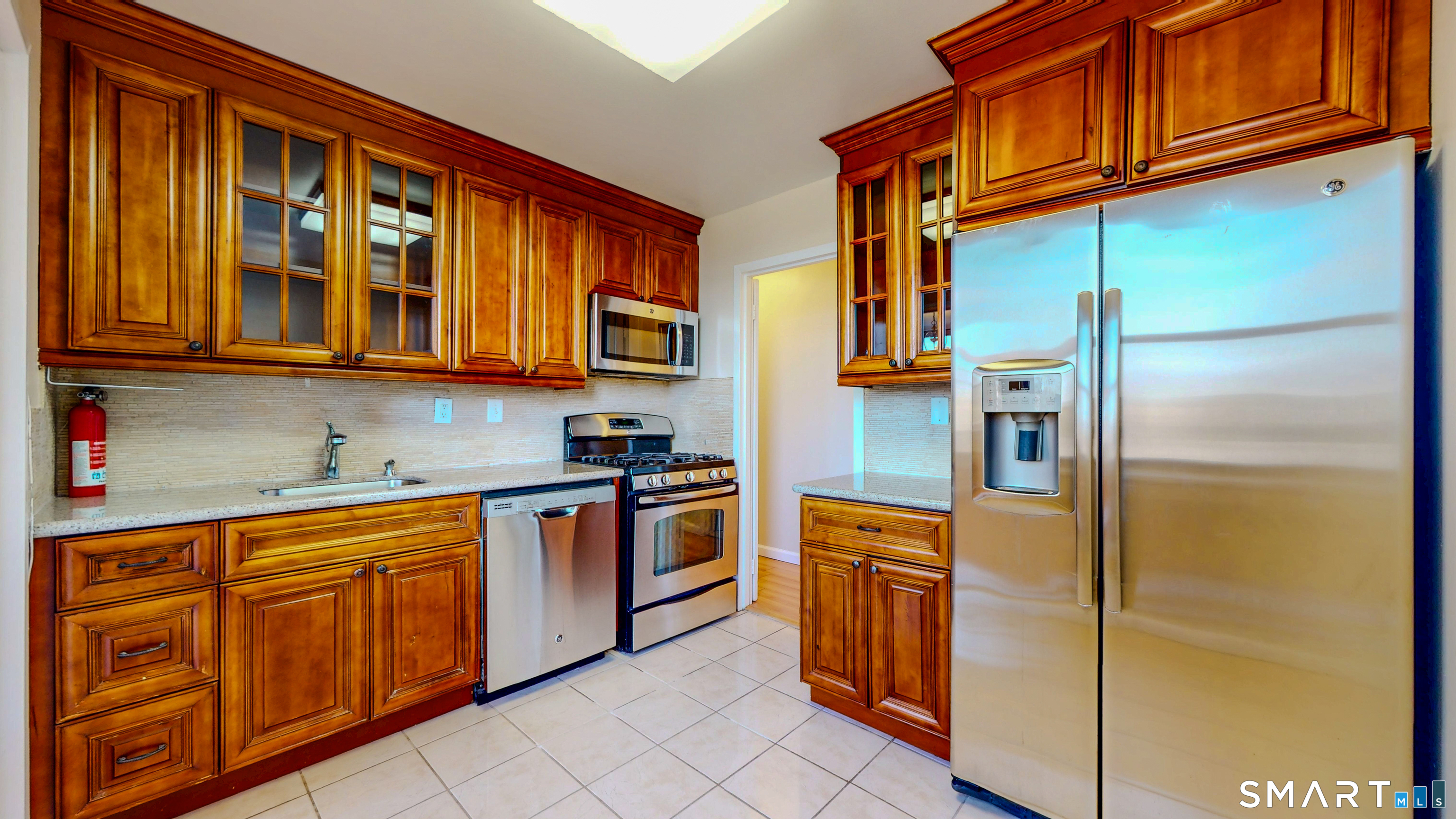 a kitchen with stainless steel appliances granite countertop a refrigerator and a stove top oven