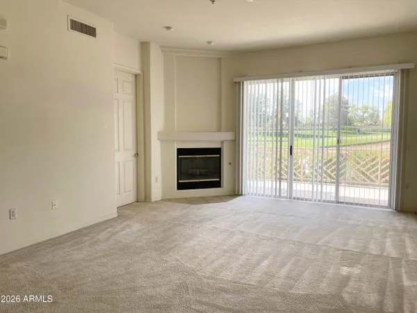 a view of an empty room with a fireplace and a window