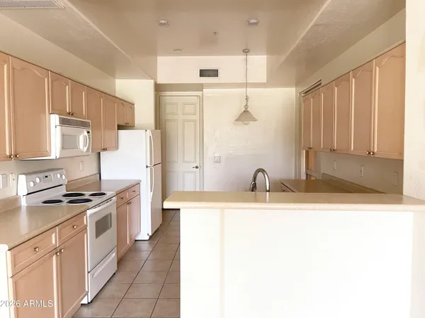 a kitchen with stainless steel appliances granite countertop a sink and a refrigerator