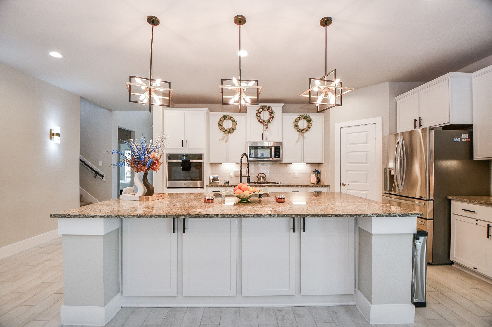 3430 Majestic Pine Lane Rosenberg, TX 77471 - Photo 5 of 32 a view of a kitchen with stainless steel appliances kitchen island granite countertop a table chairs and a wooden floor